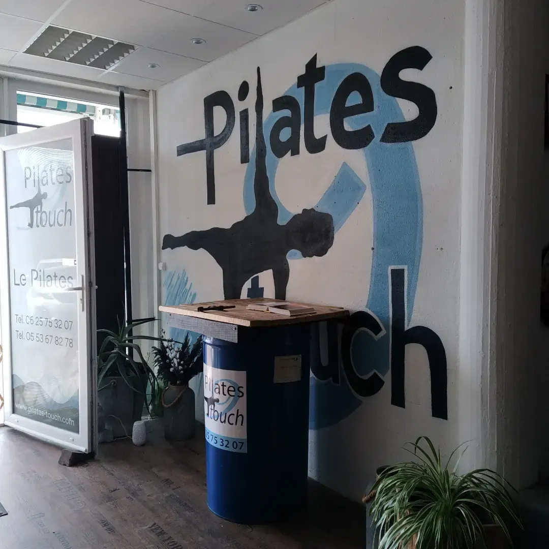 L'accueil du studio Pilates-Touch, avec son logo peint au mur.